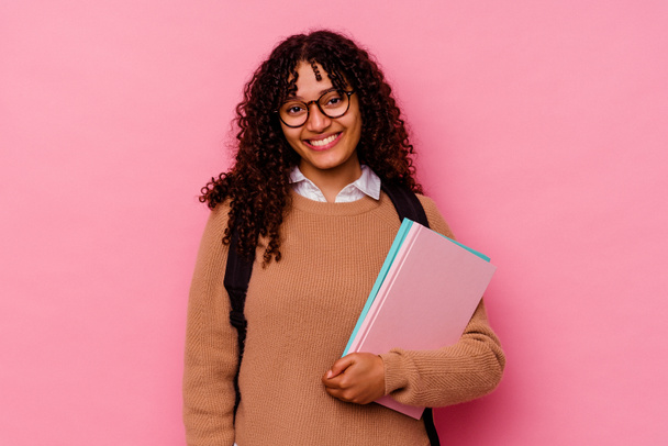 Young student mixed race woman isolated on pink background happy, smiling and cheerful. - Foto, Bild