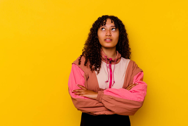 Young mixed race woman isolated on pink background tired of a repetitive task. - Photo, Image