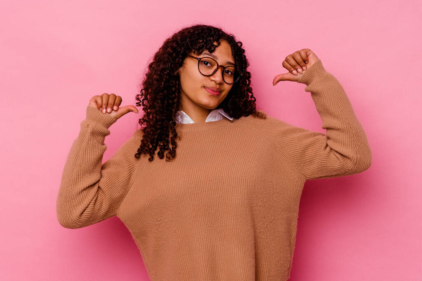 Giovane donna razza mista isolato su sfondo rosa si sente orgoglioso e sicuro di sé, esempio da seguire. - Foto, immagini