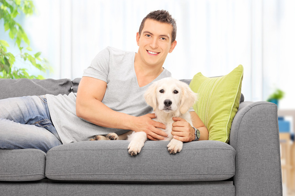 Man on couch with puppy - Fotó, kép