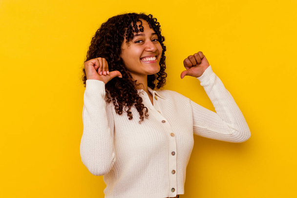Young mixed race woman isolated on yellow background feels proud and self confident, example to follow. - Fotografie, Obrázek