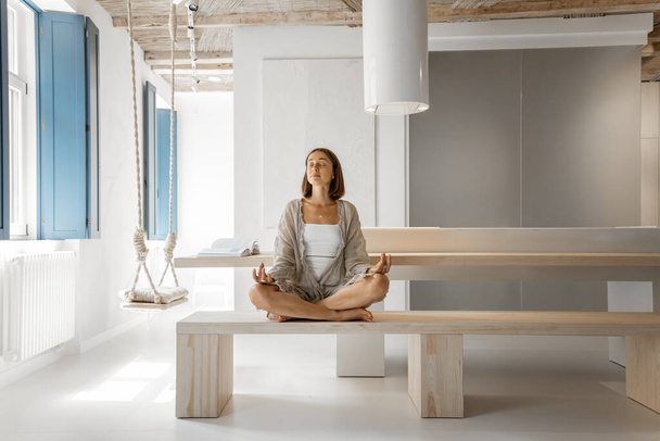 Nainen meditoi modernissa kodissa - Valokuva, kuva