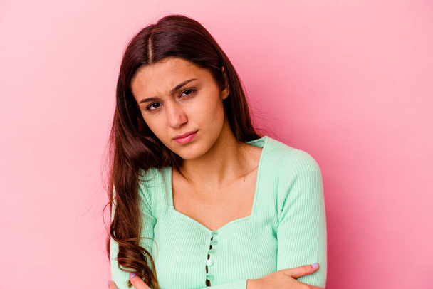 Young Indian woman isolated on pink background suspicious, uncertain, examining you. - Photo, Image