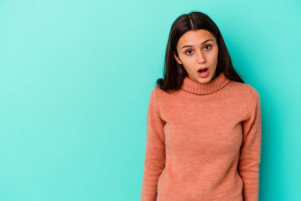 Young Indian woman isolated on blue background being shocked because of something she has seen. - Photo, Image