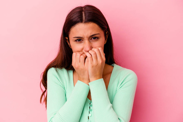 Young Indian woman isolated on pink background biting fingernails, nervous and very anxious. - Foto, Bild