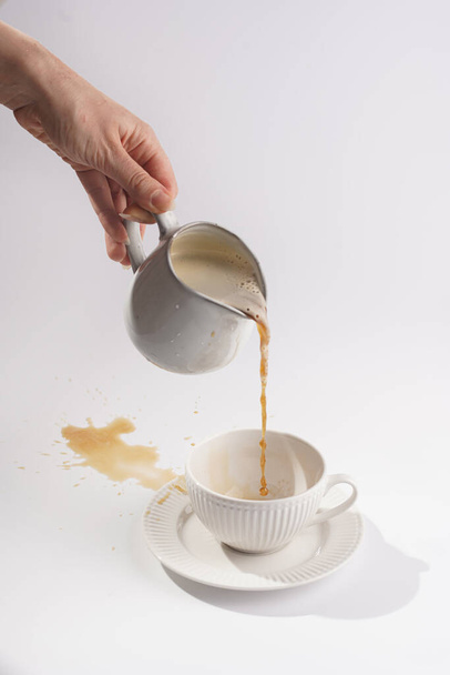 Biały porcelanowy kubek z napojem kawowym cappuccino na białym talerzu spodka na białej powierzchni - Zdjęcie, obraz
