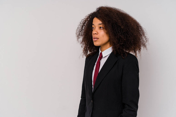 Junge afroamerikanische Geschäftsfrau trägt einen Anzug isoliert auf weißem Hintergrund und blickt nach links, seitwärts posiert. - Foto, Bild