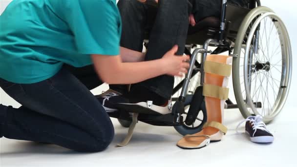 Orthopedic equipment for young man in wheelchair - Footage, Video