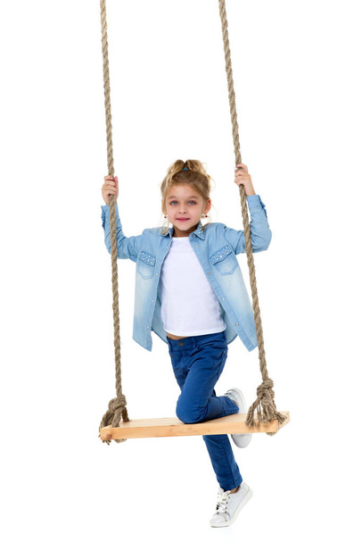 Lovely Blonde Girl Swinging on Rope Swing and Looking at Camera - Fotó, kép