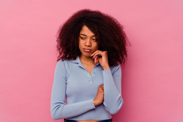 ピンクを背景に孤立した若いアフリカ系アメリカ人女性がビジネスのあり方を考え. - 写真・画像