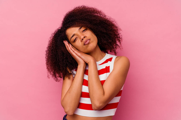 Молодая африканская американка, изолированная на розовом фоне, зевает, показывая усталый жест, прикрывающий рот рукой. - Фото, изображение