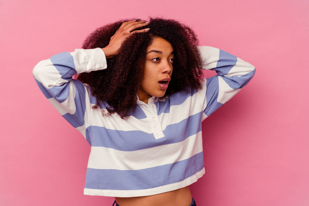 Young african american woman isolated on pink background screaming, very excited, passionate, satisfied with something. - Photo, image