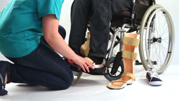 ortopéd felszerelések fiatal férfi a kerekesszék - Felvétel, videó