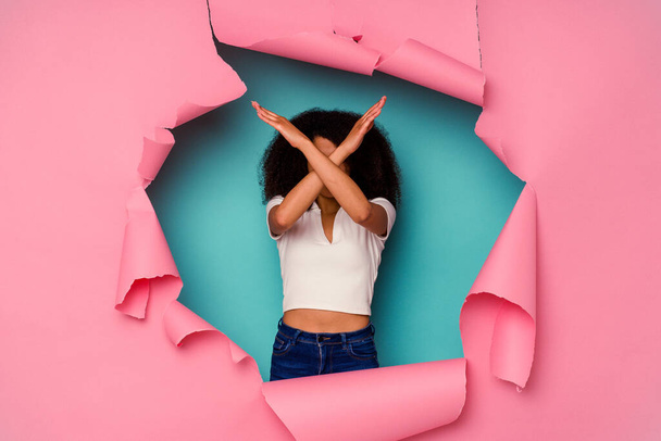 Mladá Afroameričanka v roztrhaném papíru, izolovaná na modrém pozadí, se zkříženýma rukama, popírající koncept. - Fotografie, Obrázek