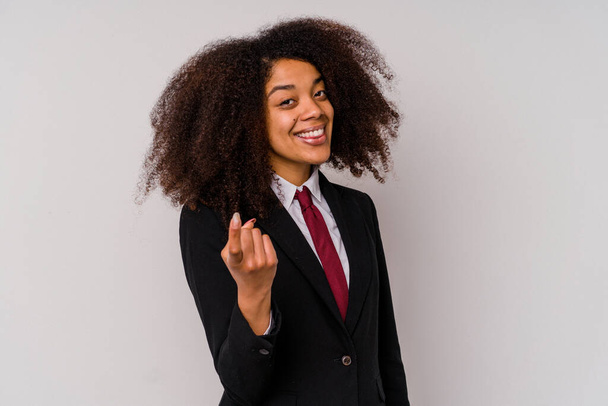 Νεαρή Αφρο-Αμερικανίδα επιχειρηματίας φορώντας ένα κοστούμι απομονωμένο σε λευκό φόντο δείχνοντας με το δάχτυλο σε σας σαν να προσκαλώντας έρθει πιο κοντά. - Φωτογραφία, εικόνα