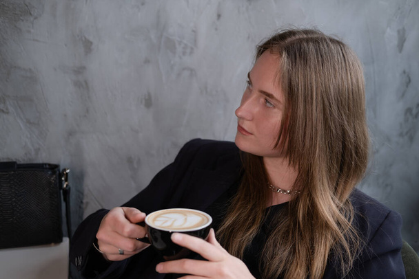 コーヒーと一緒にカフェで魅力的な自信のブルネットの女性。コーヒー休憩。ビジネスウーマン. - 写真・画像