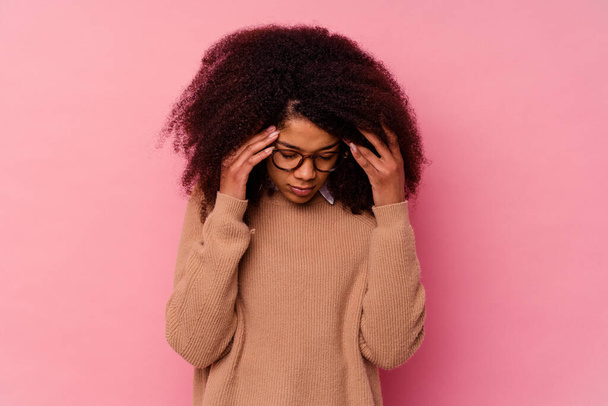 Joven mujer afroamericana aislada sobre fondo rosa tocando las sienes y teniendo dolor de cabeza. - Foto, Imagen