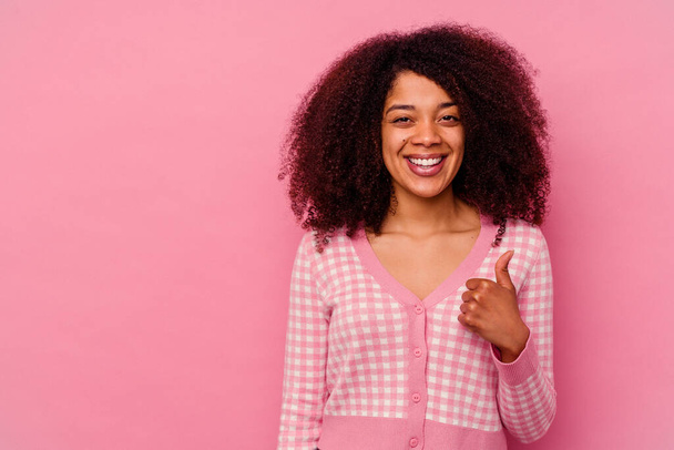 Young african american woman isolated on pink background smiling and raising thumb up - Photo, Image