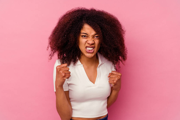 Young african american woman isolated on pink background upset screaming with tense hands. - Photo, Image