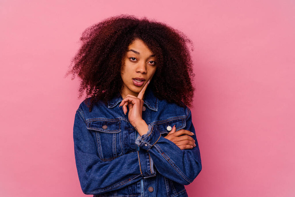 Fiatal afro-amerikai nő elszigetelt rózsaszín háttérrel, amelynek néhány nagy ötlet, koncepció a kreativitás. - Fotó, kép