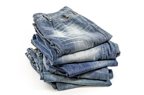 Складные старые синие джинсы, изолированные на белом. Путь обрезки включен
. - Фото, изображение