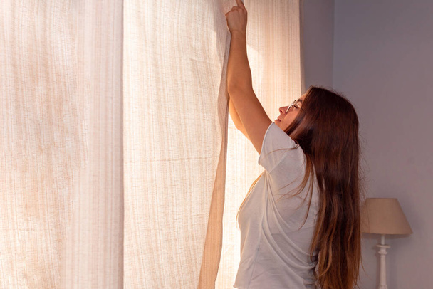 Giovane donna latina che apre la finestra al mattino - Foto, immagini