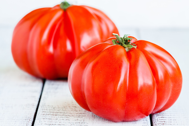 Fresh red heirloom tomatoes on a wooden background - Zdjęcie, obraz