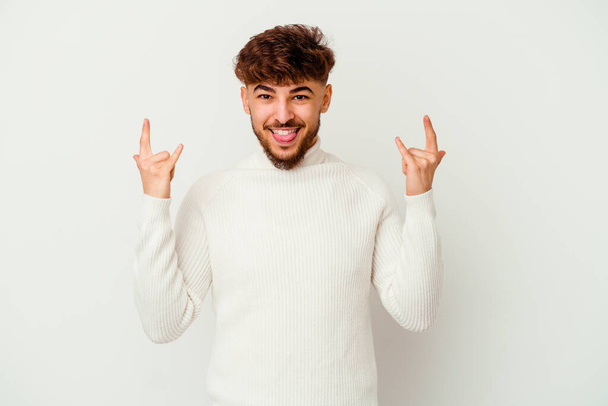 Young Moroccan man isolated on white background showing a horns gesture as a revolution concept. - Photo, Image