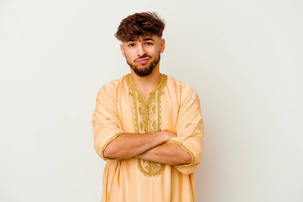 Junger marokkanischer Mann auf weißem Hintergrund isoliert und mit sarkastischem Gesichtsausdruck unglücklich in die Kamera blickend. - Foto, Bild