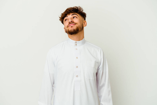Jeune homme marocain portant un vêtement arabe typique isolé sur fond blanc rêvant d'atteindre des objectifs et des buts - Photo, image