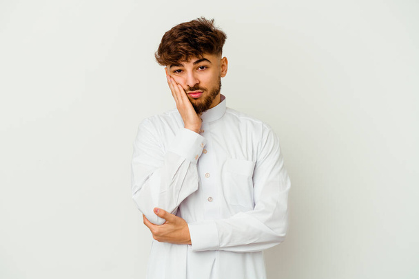 Fiatal marokkói férfi visel tipikus arab ruhát elszigetelt fehér háttér, aki unatkozik, fáradt, és szüksége van egy pihentető nap. - Fotó, kép