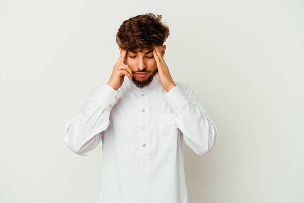 Młody Marokańczyk w typowym arabskim ubraniu odizolowany na białym tle dotykający świątyń i mający ból głowy. - Zdjęcie, obraz