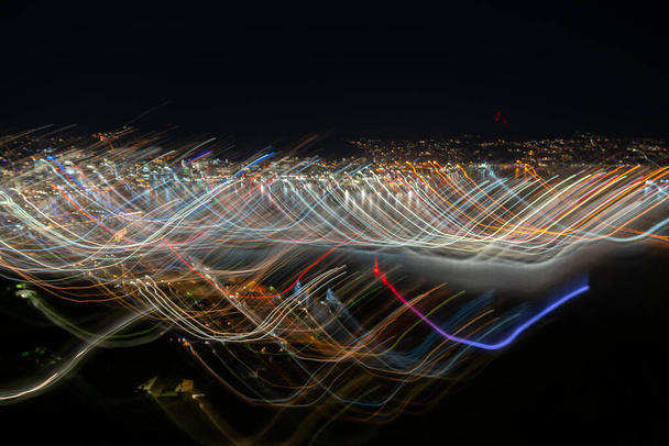Effet abstrait Lumières de nuit urbaines lumineuses de Wellington City à travers la ville avec des vagues et des motifs de couleurs à l'aide d'une longue exposition et d'un mouvement intentionnel de la caméra transmettant des hauts et des bas de la vie urbaine. - Photo, image