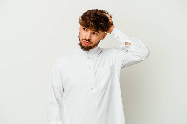 Młody Marokańczyk w typowym arabskim ubraniu odizolowany na białym tle jest wstrząśnięty, pamiętała ważne spotkanie. - Zdjęcie, obraz