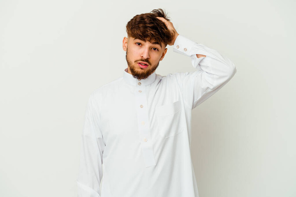 Joven hombre marroquí con una típica ropa árabe aislado sobre fondo blanco cansado y muy somnoliento mantener la mano en la cabeza. - Foto, imagen
