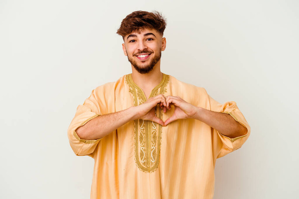 白い背景の笑顔と手で心の形を示す若いモロッコ人男性. - 写真・画像