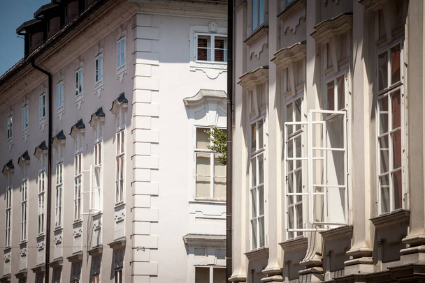 Typique austro hongrois Façades d'un ancien immeuble résidentiel rénové dans une rue de la vieille ville, avec fenêtres ouvertes, dans le centre historique de Ljubljana, en Slovénie, dans la partie touristique de la ville - Photo, image