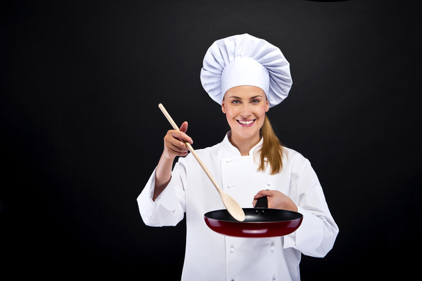 Beautiful blonde woman housewife holding pan on white dark backg - Фото, зображення