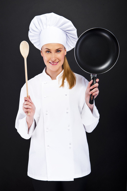 gyönyörű szőke nő chef holding pan fehér sötét háttér - Fotó, kép