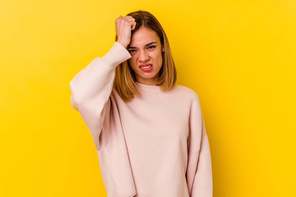 Young caucasian skinny woman isolated on yellow background forgetting something, slapping forehead with palm and closing eyes. - Photo, Image