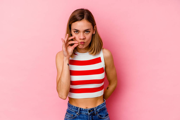 Young caucasian woman isolated on pink background with fingers on lips keeping a secret. - Φωτογραφία, εικόνα