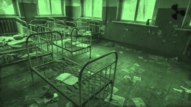 Dormitorio de niños abandonados en el jardín de infantes, detalles de una ciudad fantasma en colores geen, Pripyat, Ucrania. Moción. Espantosas camas de metal antiguas para niños dentro del edificio en ruinas. - Imágenes, Vídeo