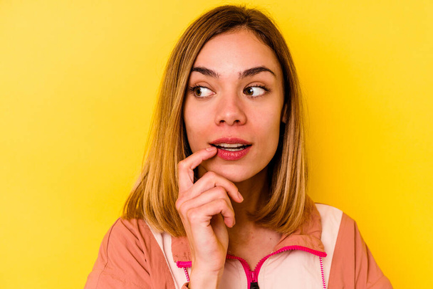 Young caucasian woman wearing invisible orthodontics isolated on yellow background - Foto, imagen
