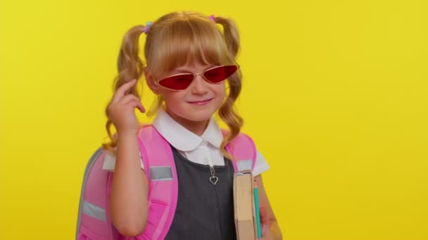 Симпатичная девочка-подросток в школьной форме и солнцезащитных очках, смотрящая в камеру с улыбкой - Кадры, видео