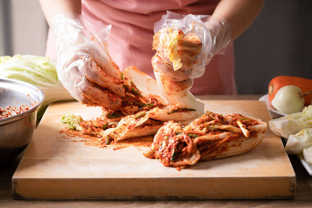 Woman making kimchi kapusta na drewnianej desce, Popularne domowe koreańskie tradycyjne sfermentowane boczne danie żywności - Zdjęcie, obraz
