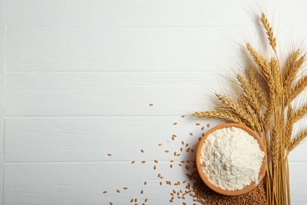 Harina de trigo y espiguillas de trigo sobre un fondo claro - Foto, imagen