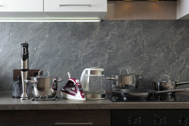 Moderne Küchen- und Haushaltsgeräte auf dem Hintergrund des Kücheninnenraums - Foto, Bild