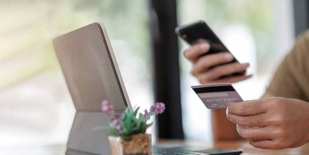 Мужчина с удовольствием пользуется приложением для онлайн-покупок и предоставляет кредитную карту для заполнения номера плательщикам - Фото, изображение