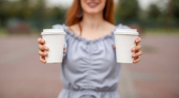 Two white paper cup with coffee in woman hand. Time for drink coffee in city. Coffee to go. Enjoy moment, take a break. Disposable paper cup closeup. Delicious hot beverage. Blank space for text, - Fotografie, Obrázek