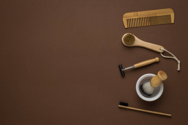 Peigne, masseur, brosse à dents et accessoires de rasage sur fond brun. Accessoires pour hommes pour soins d'apparence. Pose plate. - Photo, image